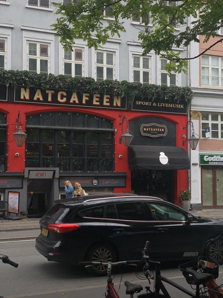 A black car outside the red-trimmed Natcafeen storefront