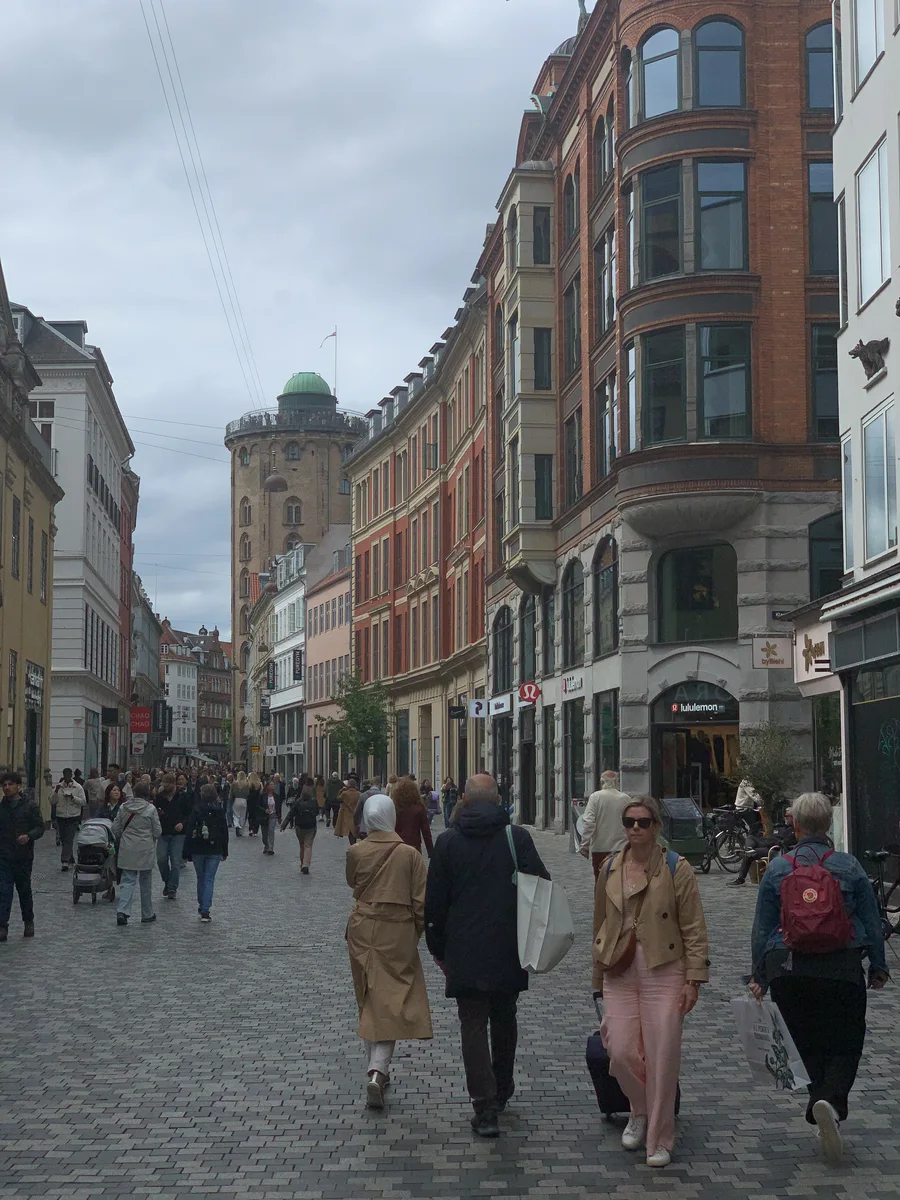 People walking along a street lined with shops and cafés