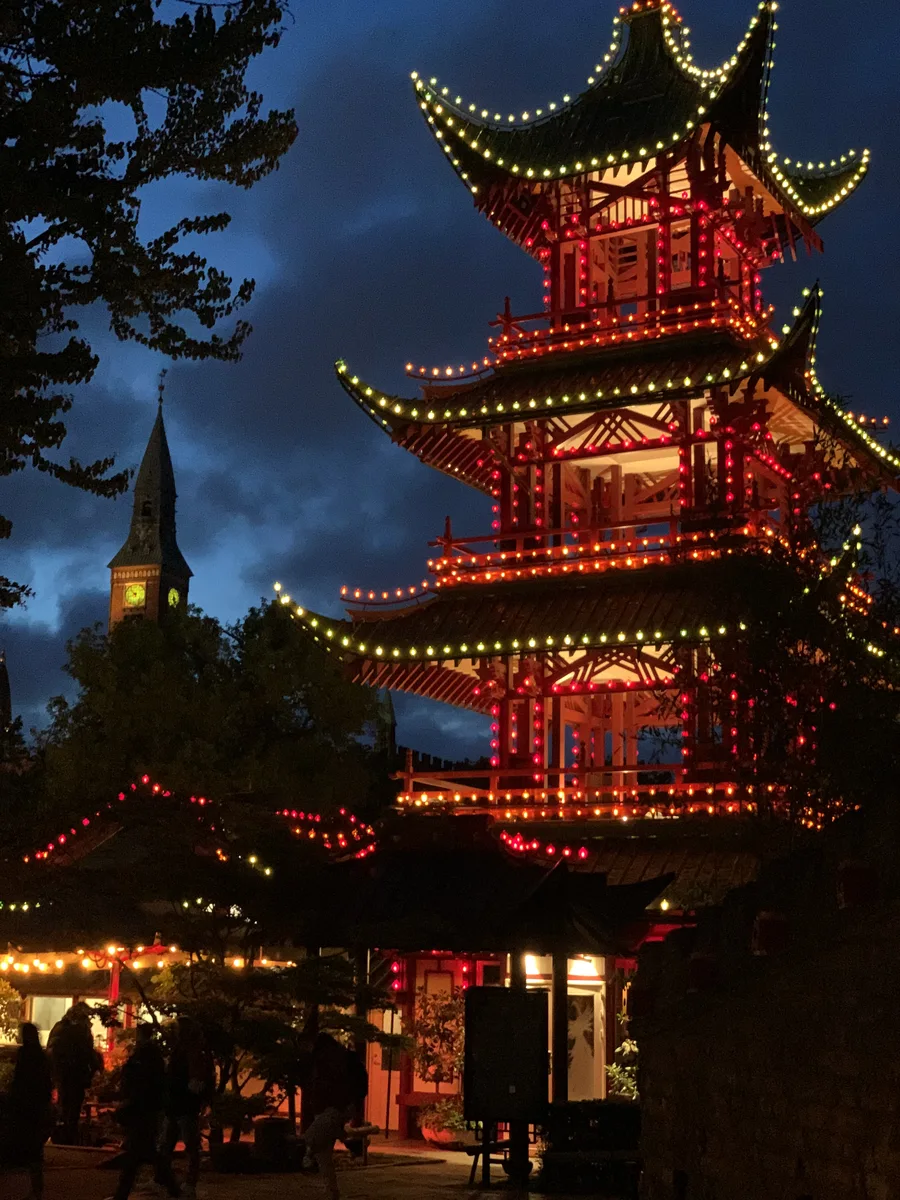 A red pagoda illuminated against the night sky