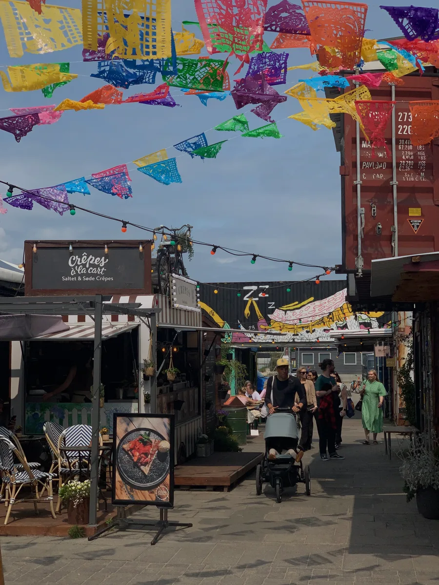 Colorful pennants suspended above a lively courtyard