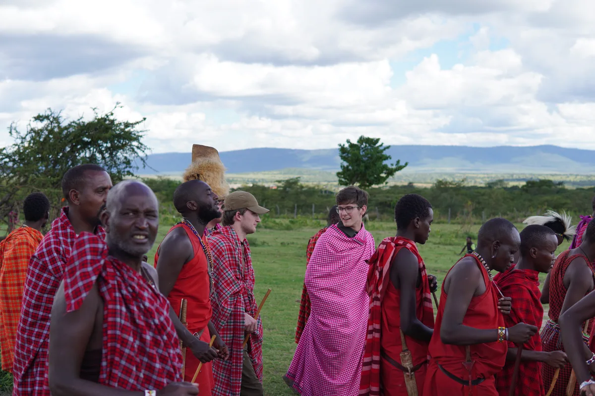 A group gathered outdoors in red and patterned wraps