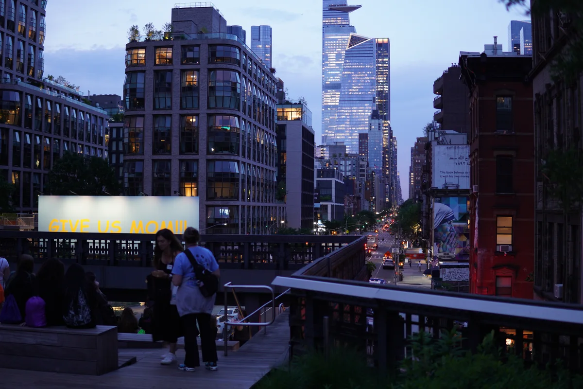 People on an elevated walkway above a Manhattan street at dusk
