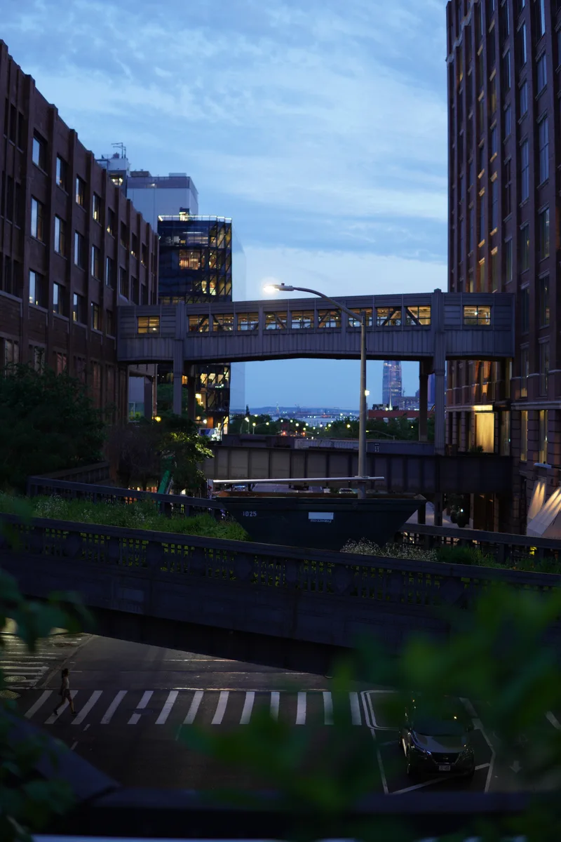 An enclosed bridge between brick buildings at blue hour