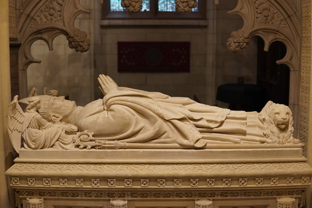 A carved reclining figure on an ornate stone tomb