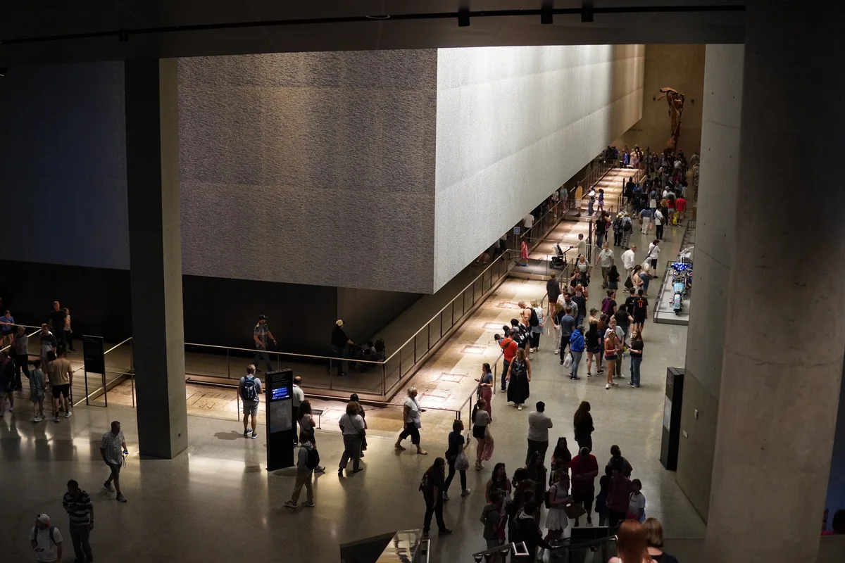 Visitors descending a long escalator in the 9/11 museum