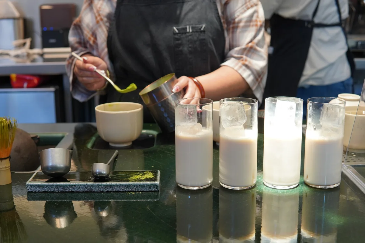 A café worker preparing matcha at a counter
