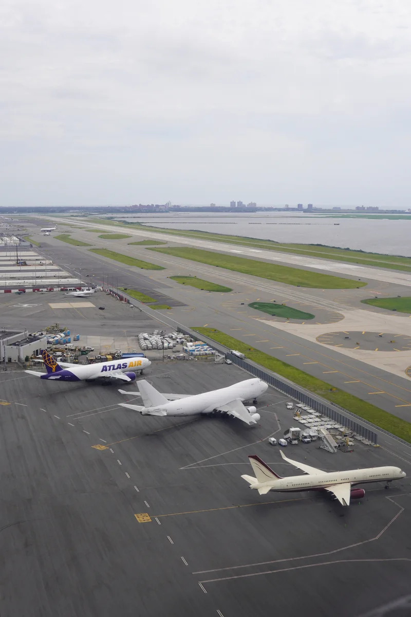 Three large aircraft parked beside the airport runways of JFK
