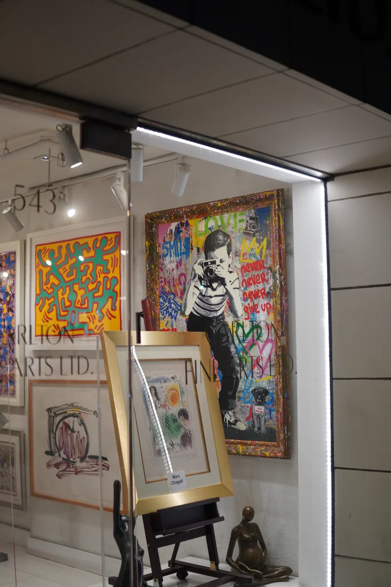 Colorful paintings seen through the windows of an art gallery